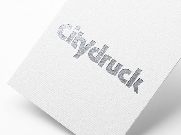 Weißes Papier mit dem gedruckten Wort "Citydruck" in Silber.