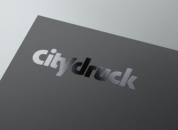 Logo mit dem Schriftzug "citydruck" in schimmerndem, grauem Design auf dunklem Hintergrund.