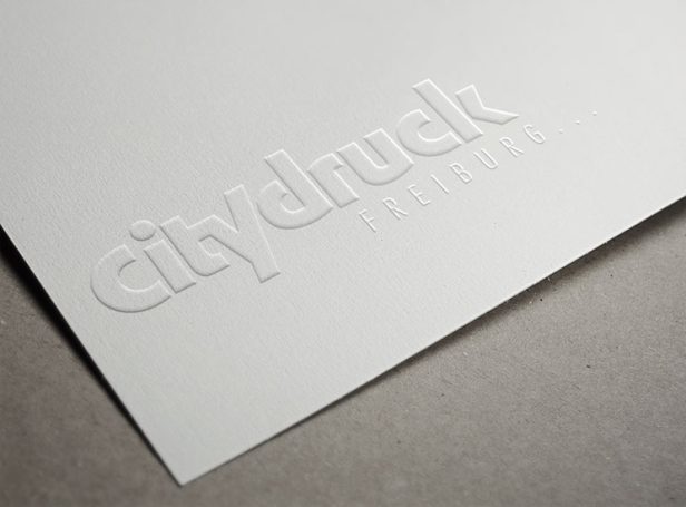 Prägung des Schriftzugs "citydruck" auf weißem Papier.